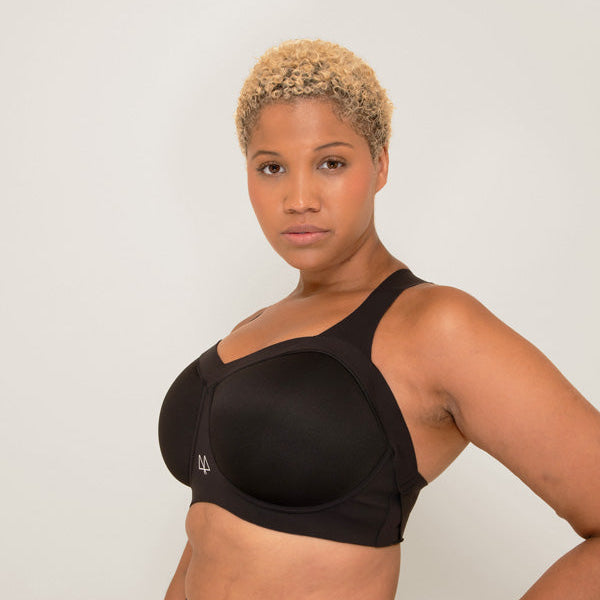 Woman wearing a black sports bra and leggings against a plain background