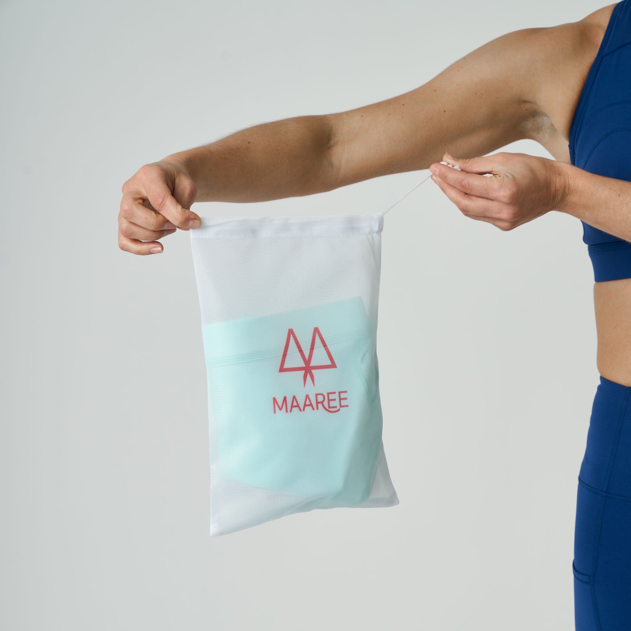 Person holding a Maaree branded wash bag against a plain background