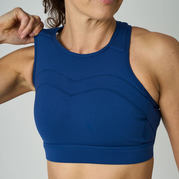 Blue sports bra worn by a person on a neutral background