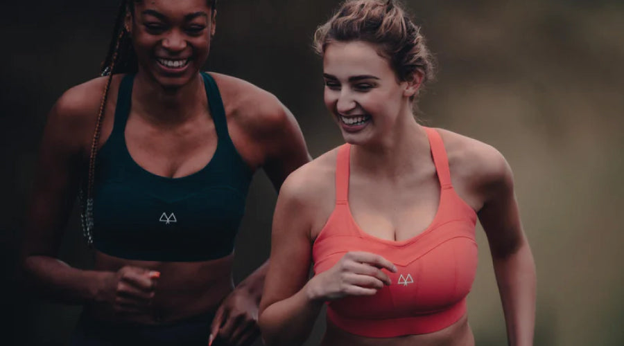 Women and Sport: How to stay safe while running. Two women running in their sports bras laughing and talking.