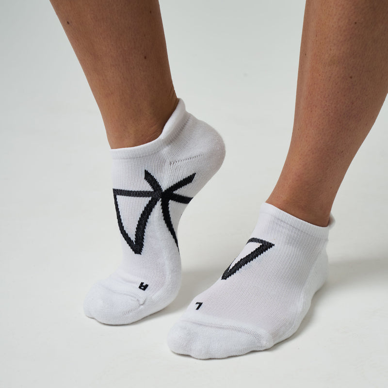 White socks with black logo worn by a person on a light gray background