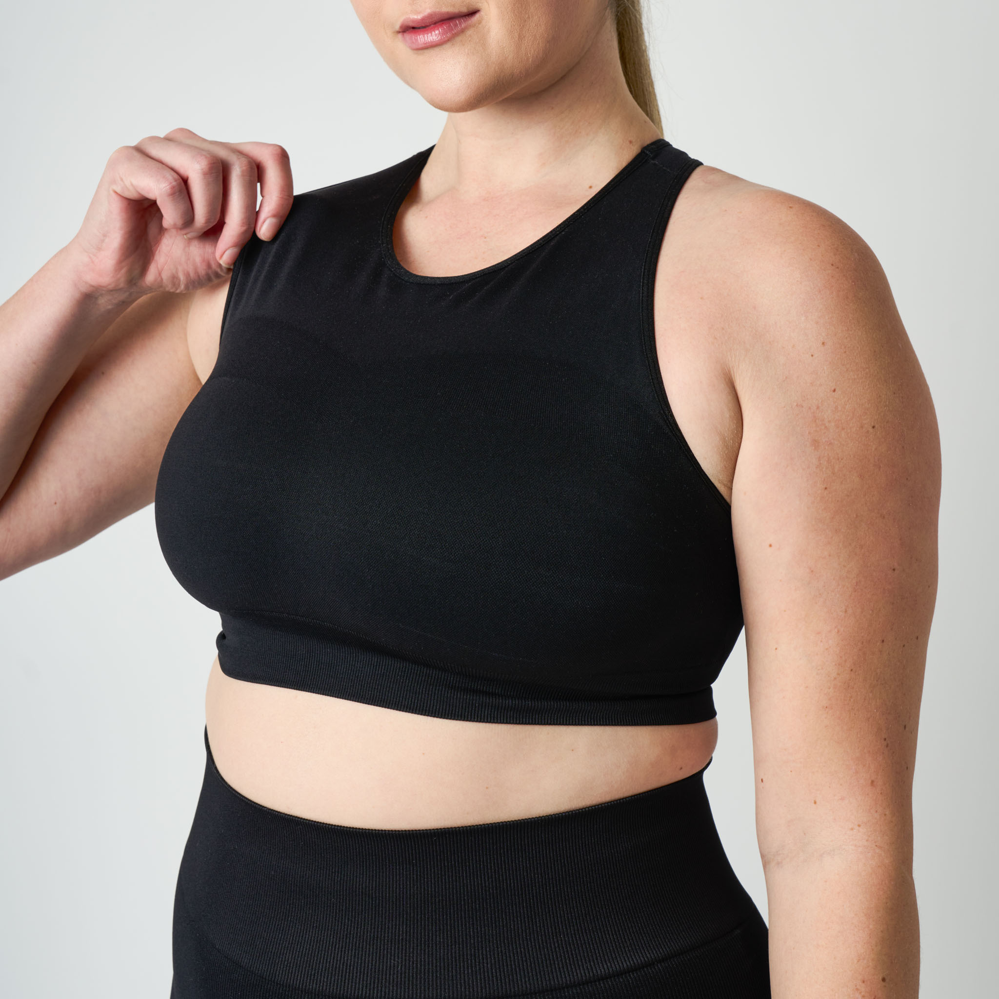 Person wearing a black athletic outfit on a plain background