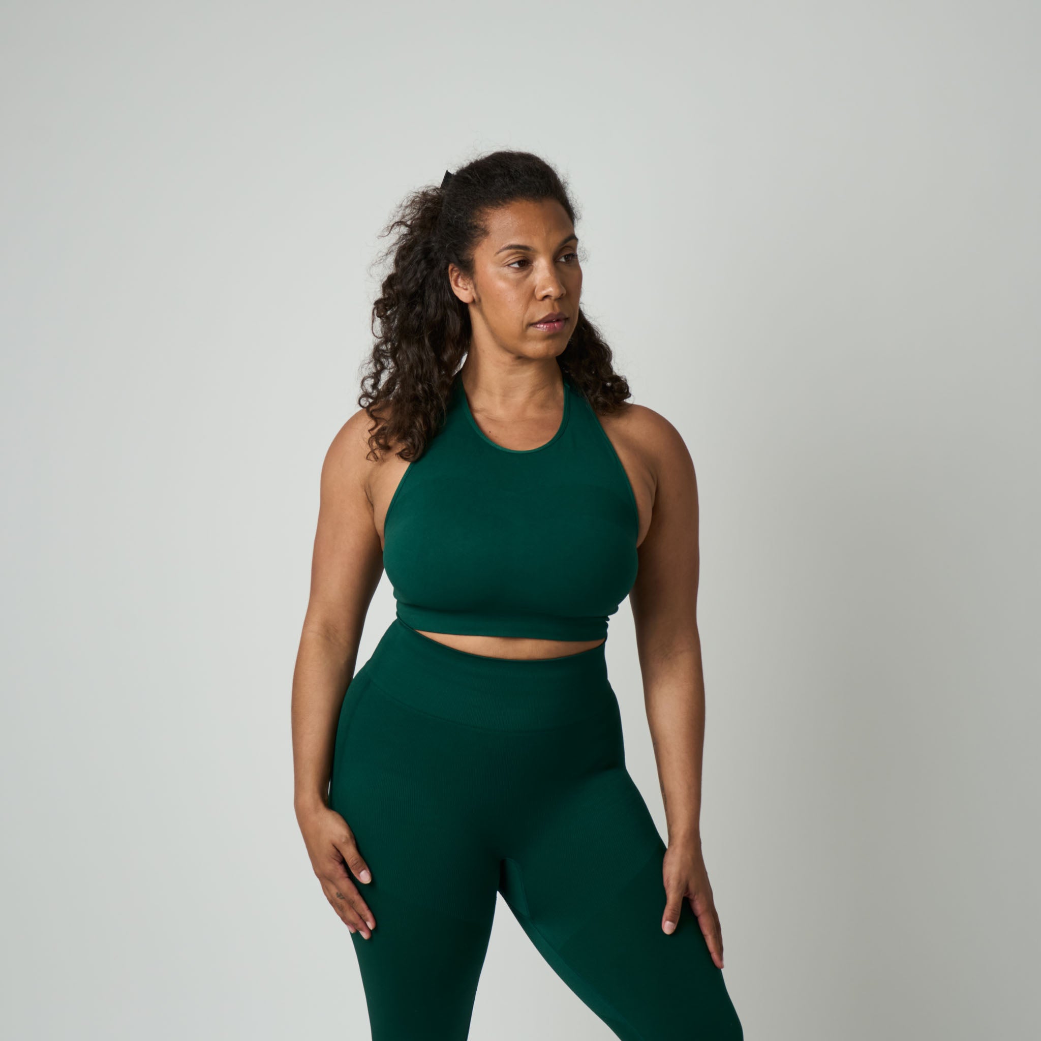Woman wearing a green athletic outfit on a plain background