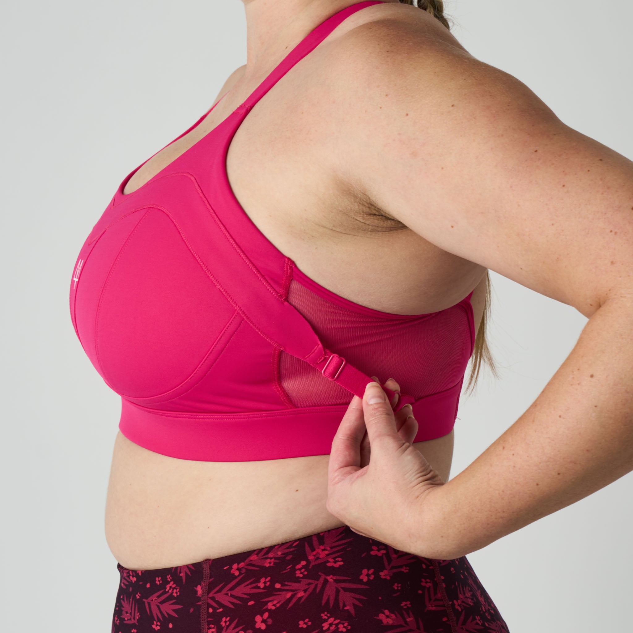 Person wearing a bright pink sports bra on a plain background