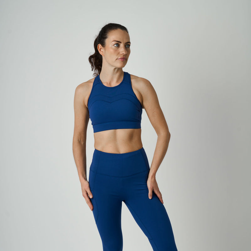 Woman wearing a blue athletic outfit on a plain background